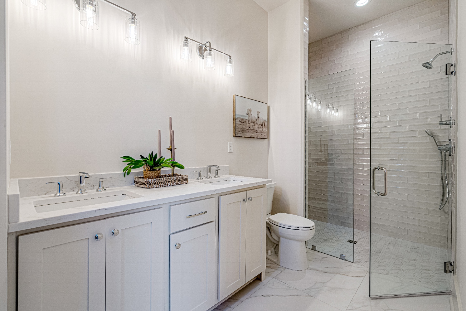 Primary bath with marble floor, glass shower, double quartz vanity