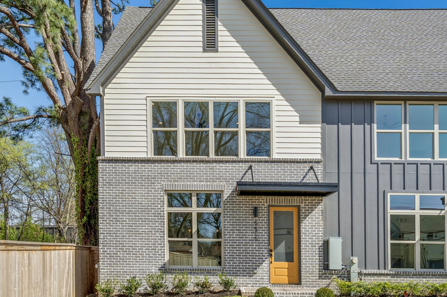 Gabled brick and siding façade with custom yellow door